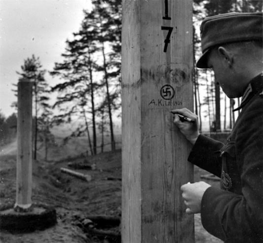 Niemiecko-sowiecka linia demarkacyjna, żołnierz Wehrmachtu dokonuje pamiątkowego wpisu na słupie granicznym.