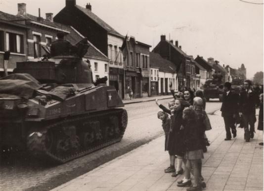 Grupa dziewcząt pozdrawia żołnierzy 1 Dywizji Pancernej gen. Maczka przejeżdzających czołgami przez belgijskie miasto. Podpis na odwrocie: 